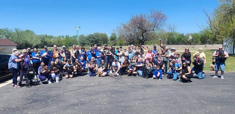 Dozens of ICT Dachshunds members gathered in a park, holding their dachshunds